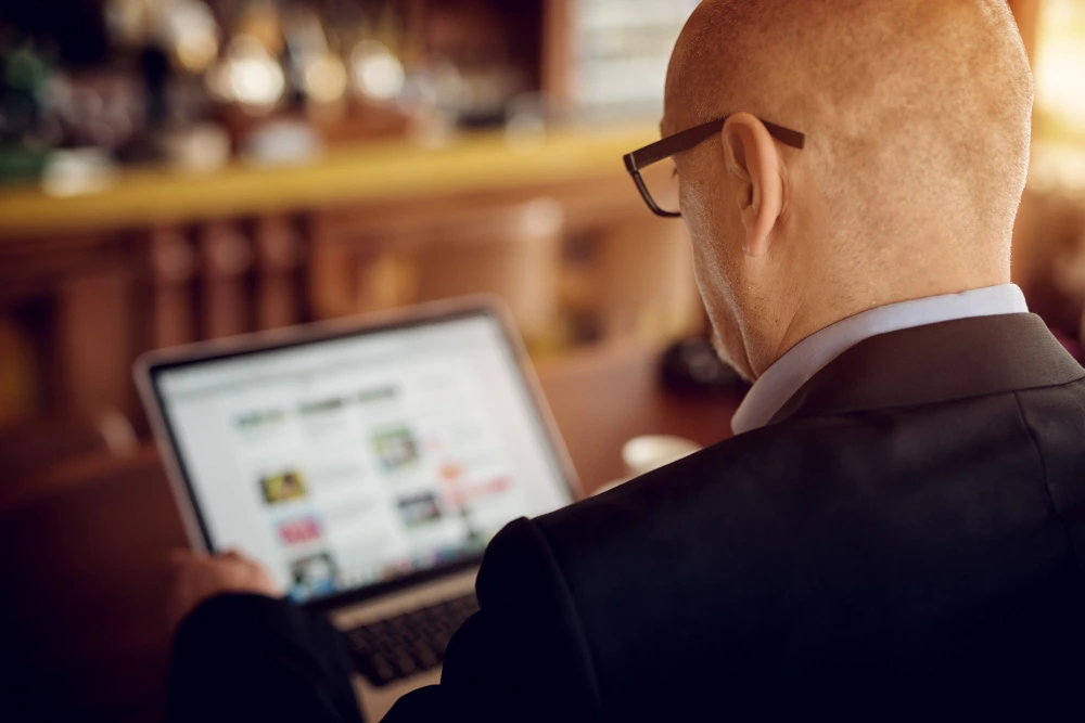 Homem de terno analisa landing page para advogados preço em laptop.