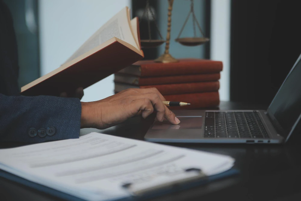 Advogado com livro e laptop, analisando se vale a pena blog jurídico.