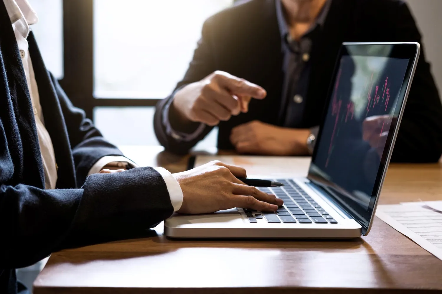 Advogados analisam gráfico no laptop, discutindo como otimizar campanhas Google Ads para advogados.