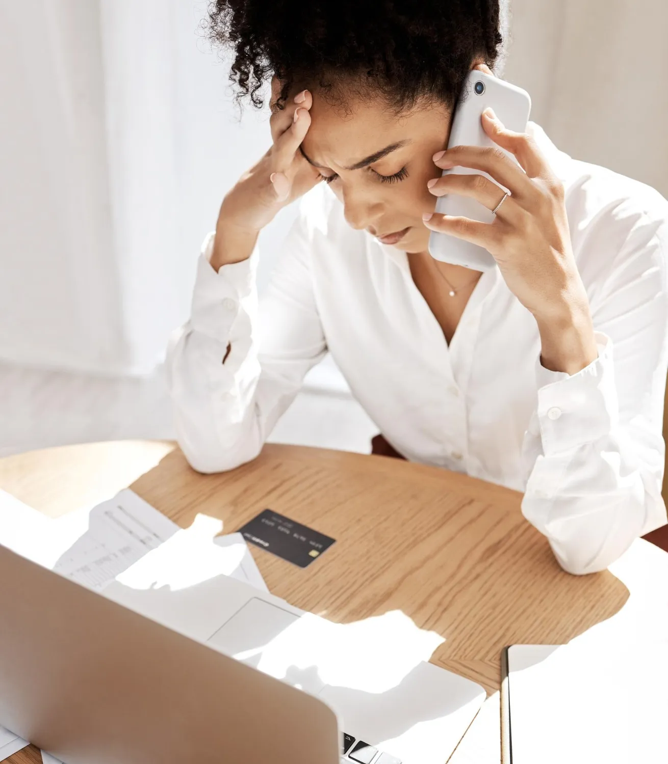Advogada estressada ao telefone, aprendendo como evitar a captação irregular de clientes.