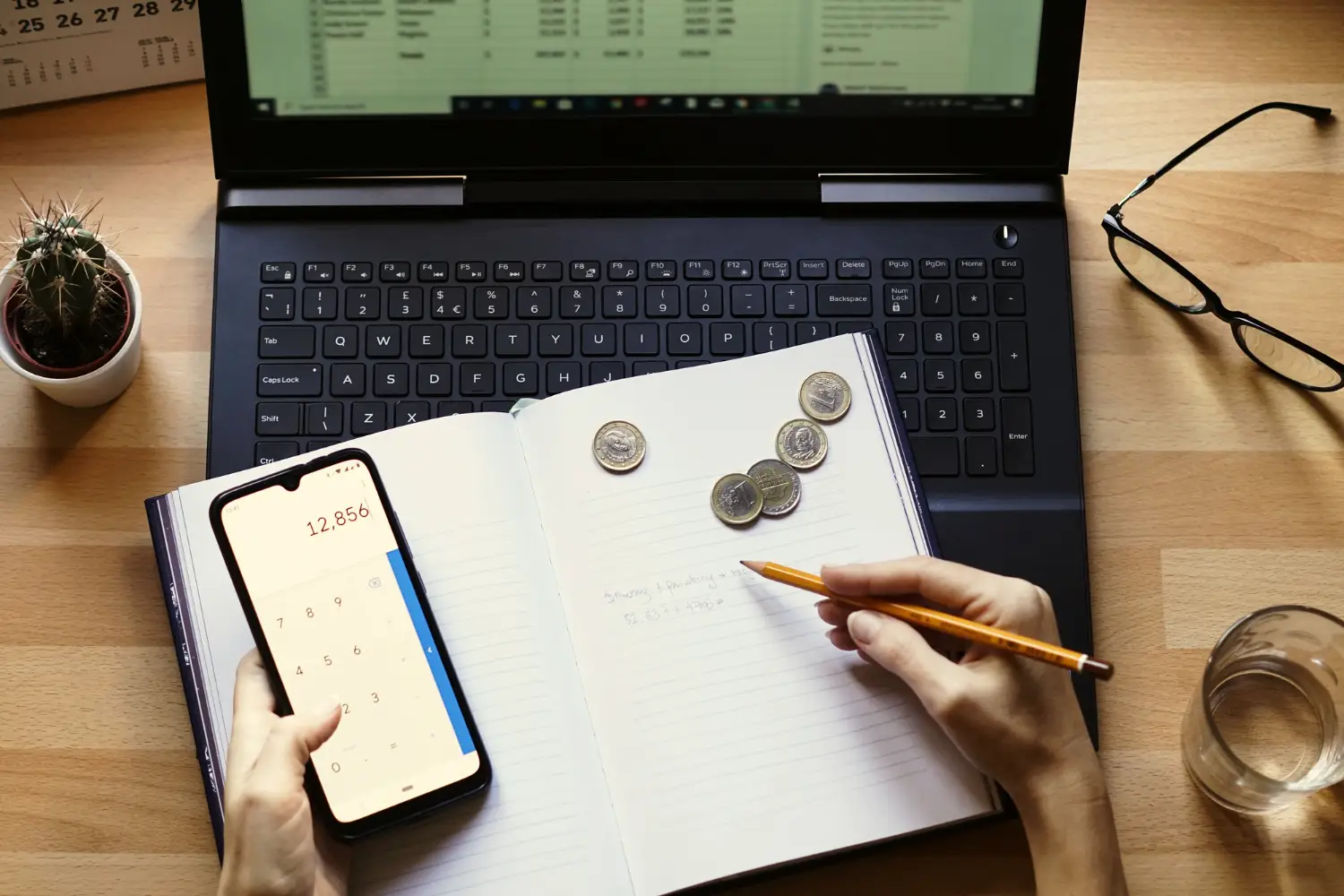 Mesa de escritório com laptop, celular, caderno e moedas para impulsionar tráfego orgânico para advogado.
